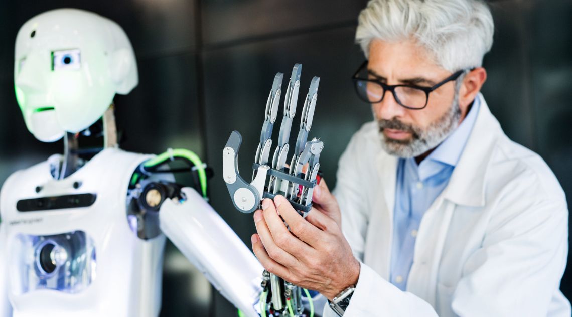 A scientist handling a robot's hand